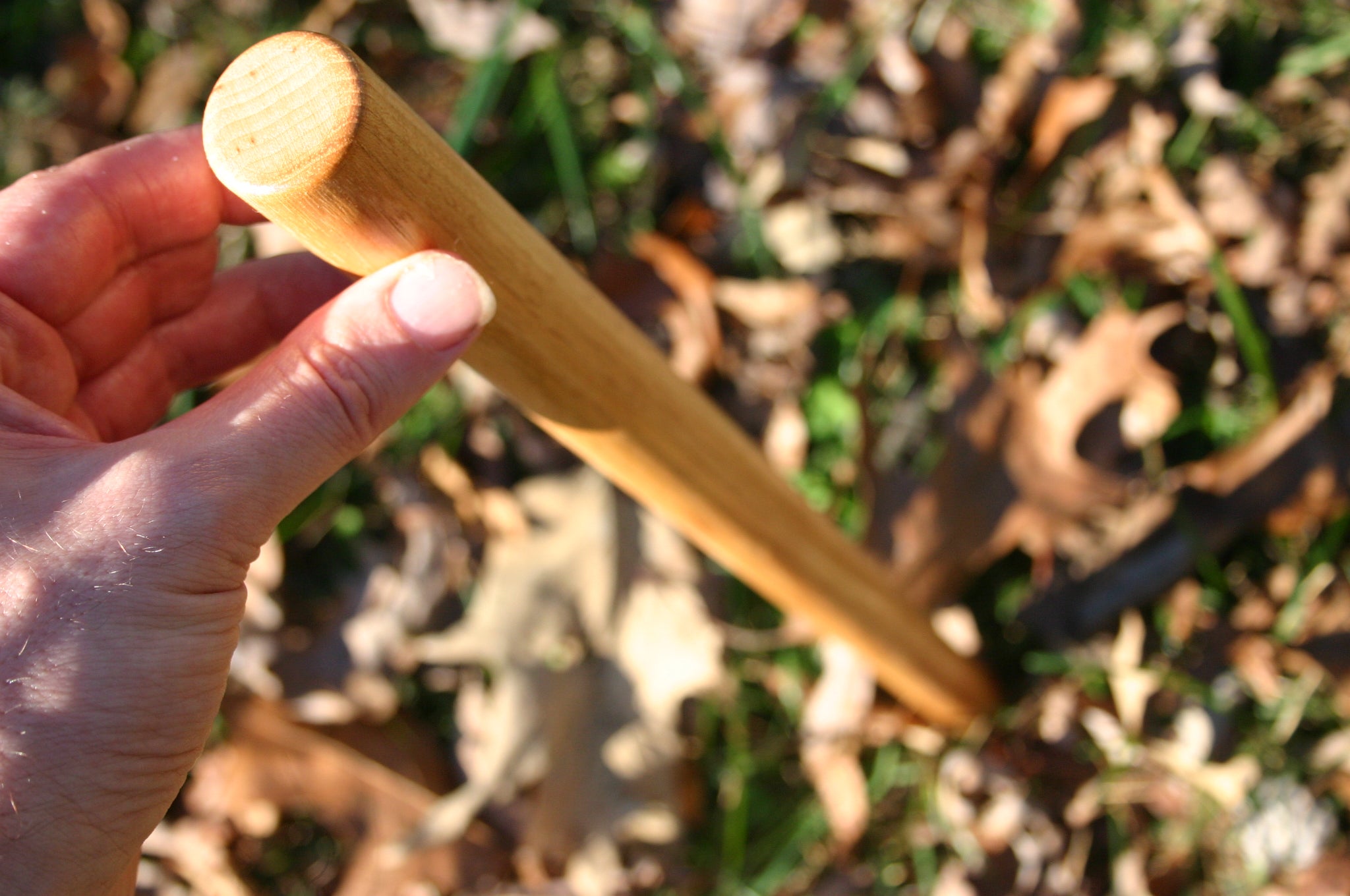 An angled shot of an arnis style martial arts weapon in fall leaves. 